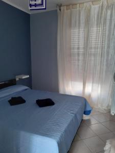 - une chambre avec un lit doté de 2 oreillers noirs dans l'établissement A due passi dal mare, à Marina di Carrara