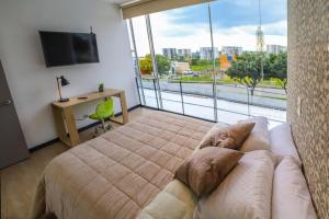 a bedroom with a bed and a large window at Metroloft 204 in Armenia