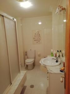 a white bathroom with a toilet and a sink at Duplex Álvaro cunqueiro, 1.3C1 in Foz