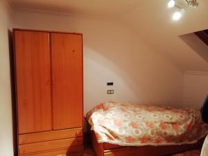 a bedroom with a bed and a wooden cabinet at Duplex Álvaro cunqueiro, 1.3C1 in Foz +7 photos
