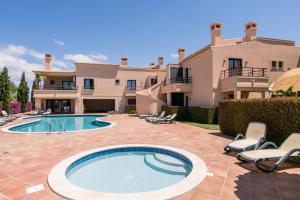 una grande casa con piscina di fronte a una casa di Mar da Luz Terrace Apt 118 a Lagos