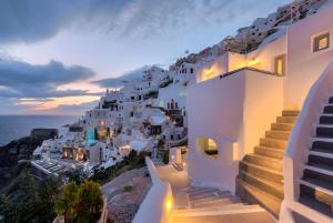 a view of a town with white buildings and the ocean at ArmonOia Luxury Caves in Oia