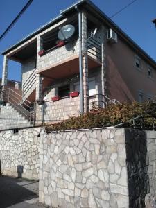 a building with a stone wall in front of a building at Studio-apartman Milena in Podgorica