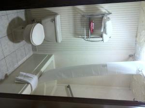 a white bathroom with a tub and a sink at Travelodge Inn & Suites by Wyndham Norman in Norman