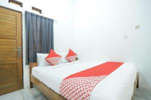 a bedroom with a bed with red and white pillows at Hotel O near Bundaran HI formerly Harmoni Residence in Jakarta