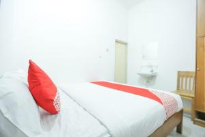 a bedroom with a bed with red pillows on it at Hotel O near Bundaran HI formerly Harmoni Residence in Jakarta +18 photos
