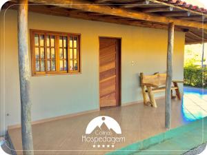 a view of a house with a wooden door at Hospedagem Colinas in Aiuruoca