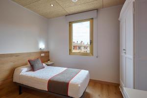 Un dormitorio con una cama y una ventana. en Hostal Nobadis, en Cervera