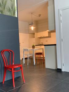 eine Küche und ein Esszimmer mit einem roten Stuhl und einem Tisch in der Unterkunft Anna Place in Gent