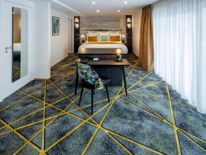 a hotel room with a king sized bed and a desk at Hôtel Villa La Florangerie - SPA & Piscine in Strasbourg