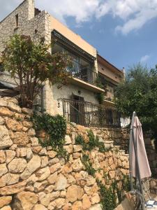 a stone wall with an umbrella in front of a house at Dieu L'Amour - Galimard in Châteauneuf