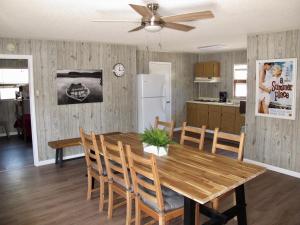 cocina y comedor con mesa de madera y sillas en Little Ted's Cottages, en Marblehead