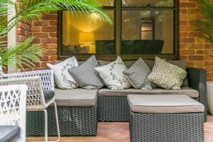 un banco lleno de almohadas en el patio en Calinda Sol 2 @ Clarkes Beach, en Byron Bay