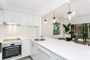 Una cocina blanca con fregadero y encimera. en Calinda Sol 2 @ Clarkes Beach, en Byron Bay