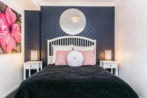 Un dormitorio con una cama grande con almohadas rosas. en Calinda Sol 2 @ Clarkes Beach, en Byron Bay 15 fotos más