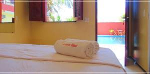 a towel on a bed in a room with a pool at Pousada Vital in Jericoacoara +42 photos