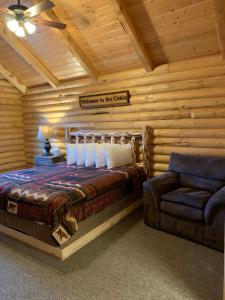 Dormitorio en cabaña de madera con cama y sofá en Countryside Cabins en Panguitch