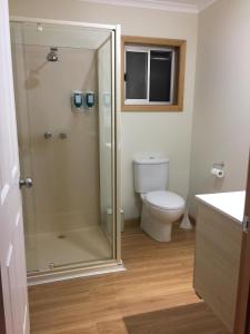 La salle de bains est pourvue de toilettes et d'une douche en verre. dans l'établissement White Sands Estate unit 20, à Four Mile Creek