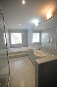 a bathroom with two sinks and a tub and a shower at Mandurah Quay Resort in Mandurah