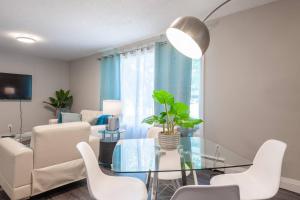 ein Wohnzimmer mit einem Glastisch und weißen Stühlen in der Unterkunft ENTIRE 2 BEDROOM APARTMENT UPTOWN WATERLOO - e2 in Waterloo