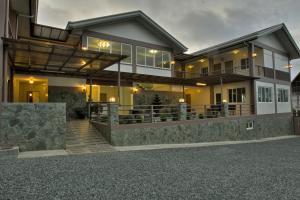 a large house with a porch and a stone driveway at Tagaytay Wingate Manor in Tagaytay