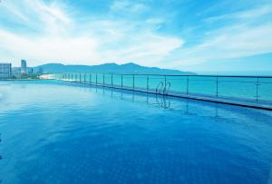 a swimming pool with a view of the ocean at Muong Thanh Luxury Da Nang Hotel in Danang