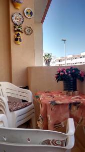 stół i krzesła na balkonie ze stołem i kwiatami w obiekcie Apartment Manuel Galián 52 w mieście Torrevieja