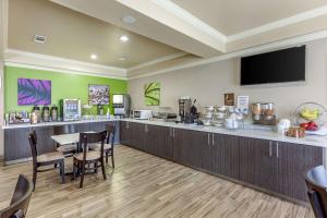 a restaurant with a bar with a table and chairs at Sleep Inn & Suites Hewitt - South Waco in Hewitt