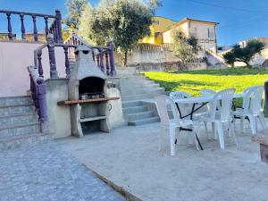 un patio con mesa, sillas y horno de pizza en Catloc & Kitcat Alojamento Local, en Costa de Além