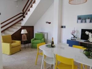 a living room with a white table and yellow chairs at Villa Piera in Mondello