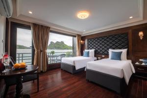 Habitación de hotel con 2 camas y ventana en La Pandora Cruises, en Ha Long