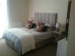 ein Schlafzimmer mit einem großen Bett mit Kissen in der Unterkunft 4 On Braemar in Nottingham Road