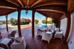 un patio con sillas blancas y una piscina en residence scala dei turchi en Realmonte