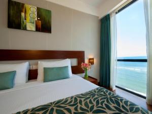 a bedroom with a large bed and a large window at The Ocean Colombo in Colombo