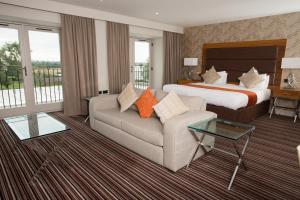 a hotel room with a bed and a couch at Sketchley Grange Hotel in Hinckley