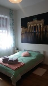 ベルリンにあるFerienwohnung 3の壁に絵が飾られたベッドのある寝室