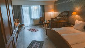 a hotel room with a bed and a desk at Hotel Büchner Garni in Bad König