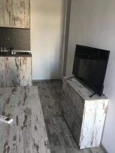 a living room with a tv on a wooden chest at Хотел Paradise in Tsarevo