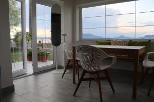 a dining room with a table and chairs and windows at Exclusive Beachfront Villa in Fonyód