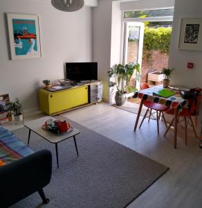 a living room with a yellow cabinet and a table at Tressell in Hastings