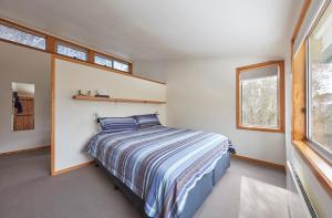 um quarto com uma cama num quarto com janelas em Ripparoo Lodge em Falls Creek