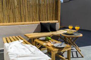 une table avec deux verres de jus d'orange et un canapé dans l'établissement Echo Caves Suites, à Fira