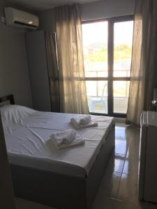 a bed with towels on it in a room with a window at Хотел Paradise in Tsarevo