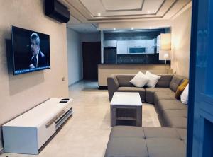 - un salon avec un canapé et une télévision dans l'établissement Haut standing beach apartment, à Tanger