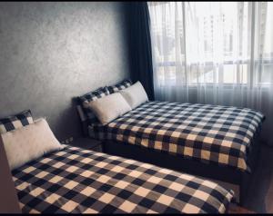 - 2 lits dans une petite chambre avec fenêtre dans l'établissement Haut standing beach apartment, à Tanger