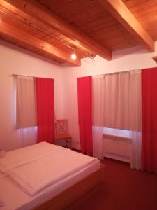 - une chambre avec des rideaux rouges et un lit dans l'établissement Ferienhof Kirchau, à Göstling an der Ybbs