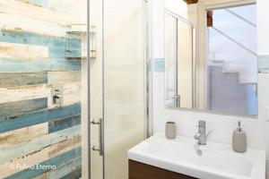 a bathroom with a sink and a glass shower at Casa vacanza oscar in Castellammare del Golfo