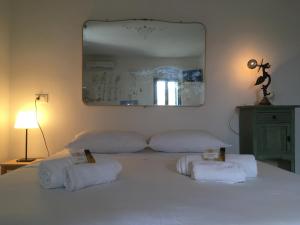 a bedroom with a large white bed with towels on it at Dimore Sicule Noto in Noto