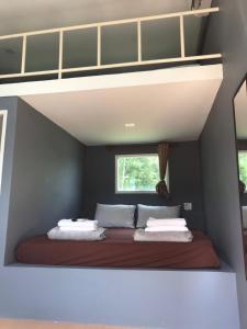 Bett in einem kleinen Zimmer mit Fenster in der Unterkunft River&Mountain Resort in Nakhon Nayok