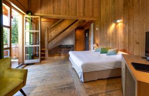 a bedroom with a bed in a room with wooden walls at Hotel du Golf in Corrençon-en-Vercors +83 photos